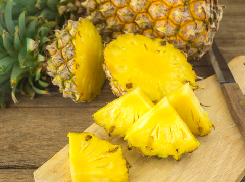 pineapple and pineapple slice on wood table