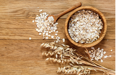 Rolled oats and oat ears of grain on a wooden table