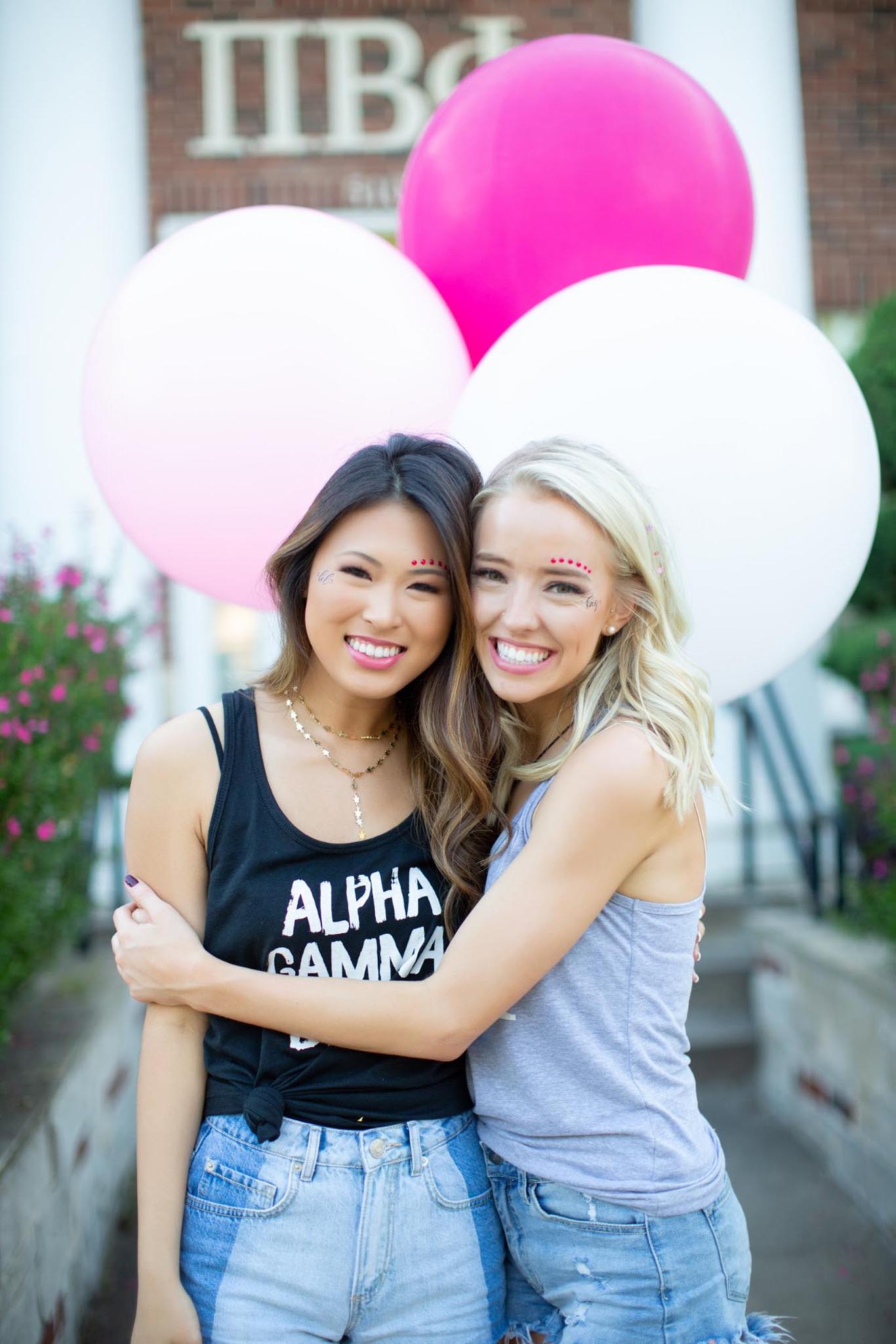 Girls posing in front of sorority house with balloons