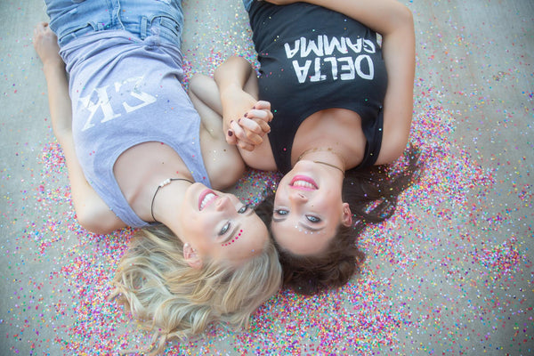 Sorority girls posing and lying on ground surrounded by confetti