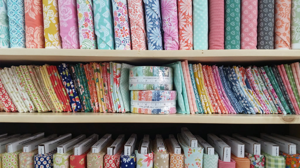 shelves stocked with fabric, fat quarters, and jelly rolls.