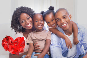 Happy family posing on the couch together against heart