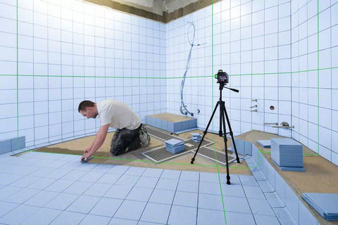 Laser Level on tripod in a room being tiled from floor to ceiling