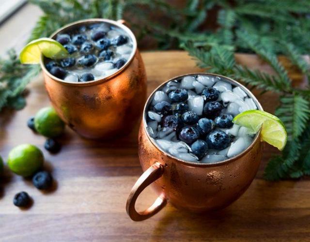 two copper mugs filled with liquid ice blueberries