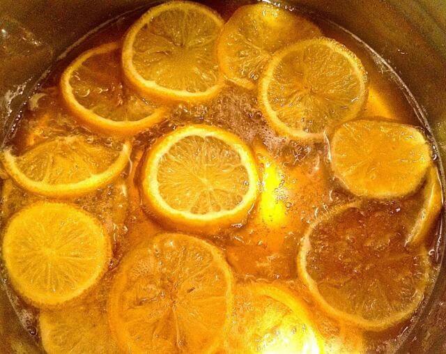 pot filled with liquid bubbling and orange slices 