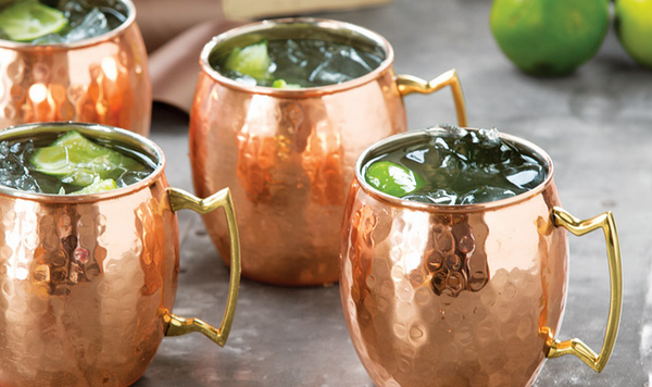 Moscow Muled copper mugs filled with clear liquid ice cubs and lime slices