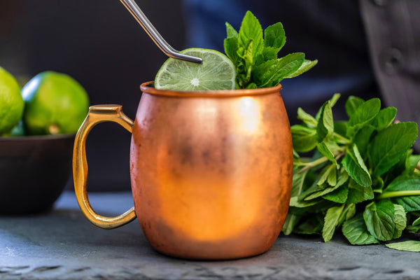 copper mug side view with slice lime and mint leaves