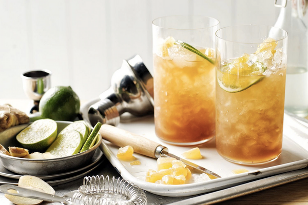 two clear glass filled with yellow liquid ice and citrus slices