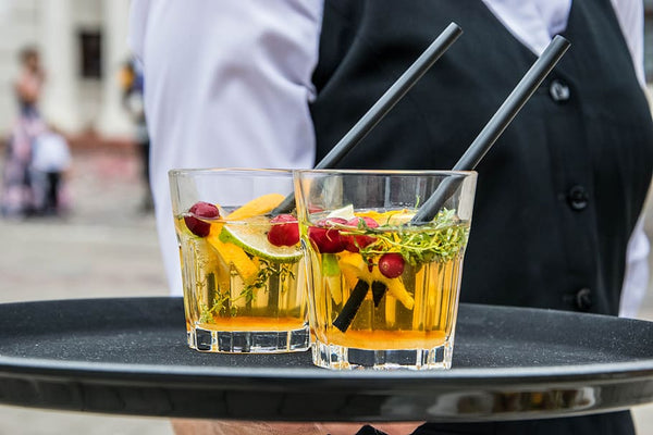 beverage placed on a black tray being carried by a waiter