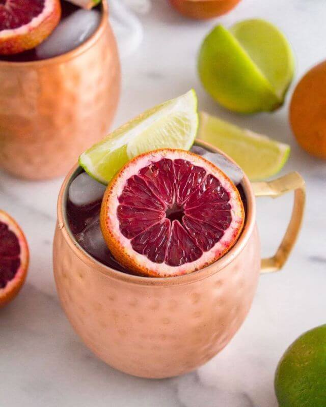 Moscow Muled copper mug filled with liquid ice pomegranate and lime slices
