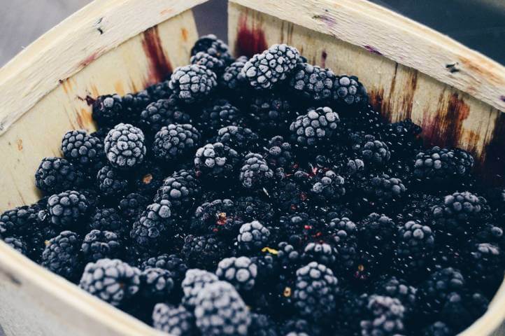 wooden box filled with blackberries close up view