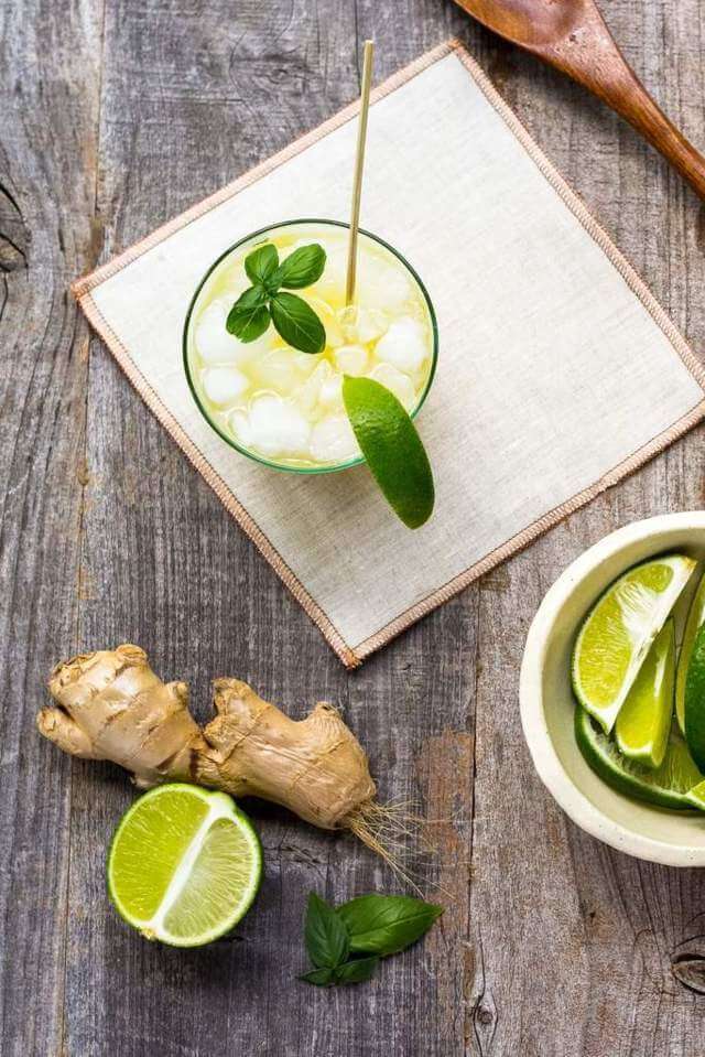 cup filled with yellow liquid ice and mint leaves