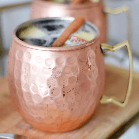 Moscow Muled copper mug filled with liquid ice and sliced lime on its rim