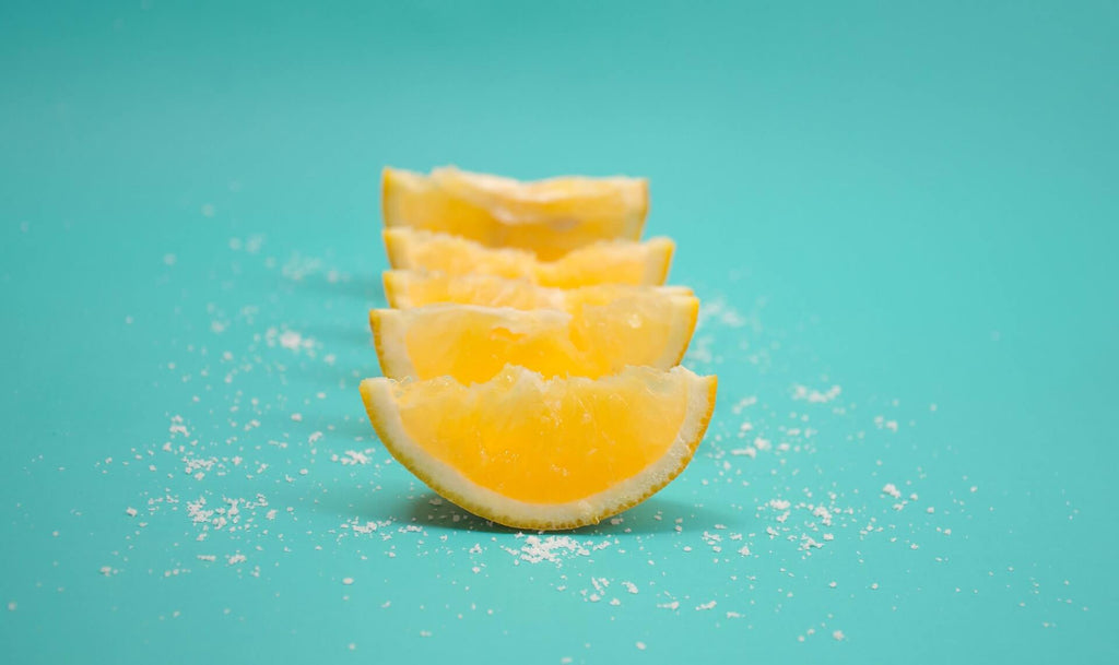 four slices of lemon lined up and sprinkled with salts