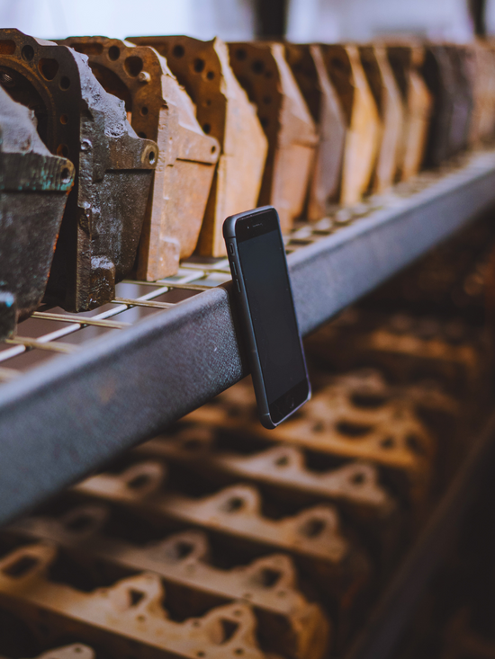 iPhone with ROKFORM magnetic case attached to metal shelf