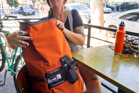 Road Runner Bags Medium Roll Top Pro in Rust being cycling by bike around los angeles city by a commuter