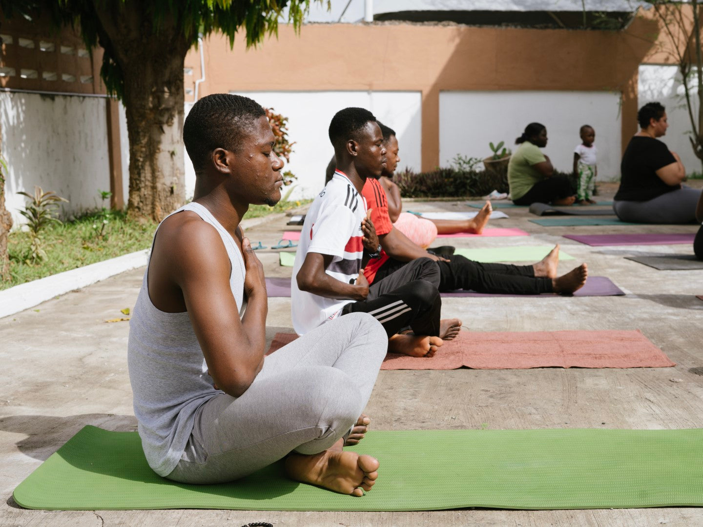 Group yoga session with colorful mats, promoting team wellness and unity at Osei-Duro’s Accra headquarters.