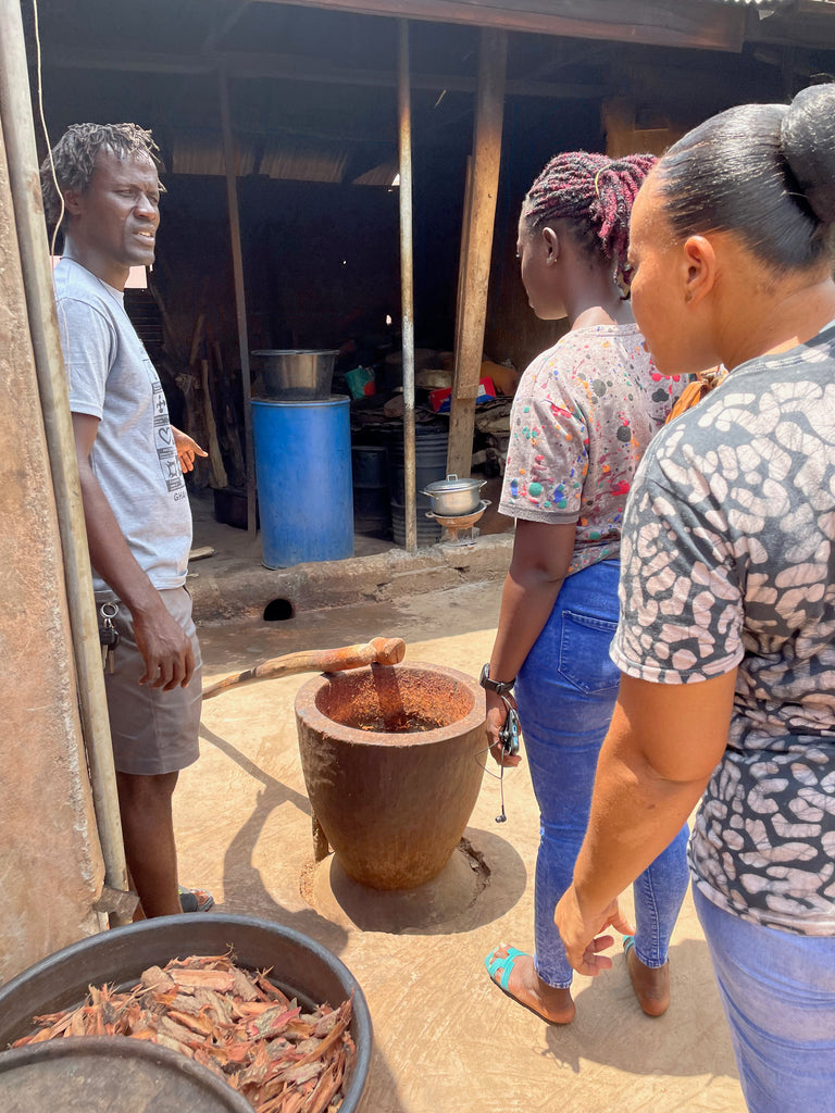Three individuals engage in outdoor botanical dyeing activities, in Kumasi.