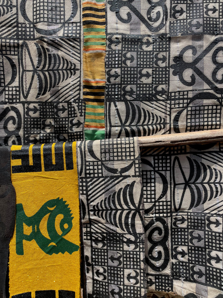 Assortment of fabrics with bold patterns, including a yellow background with a fish symbol and geometric designs.