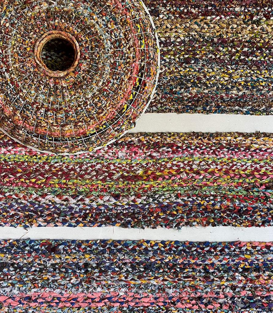 Close-up of a colorful braided rug, showcasing the intricate craftsmanship of handmade textiles.