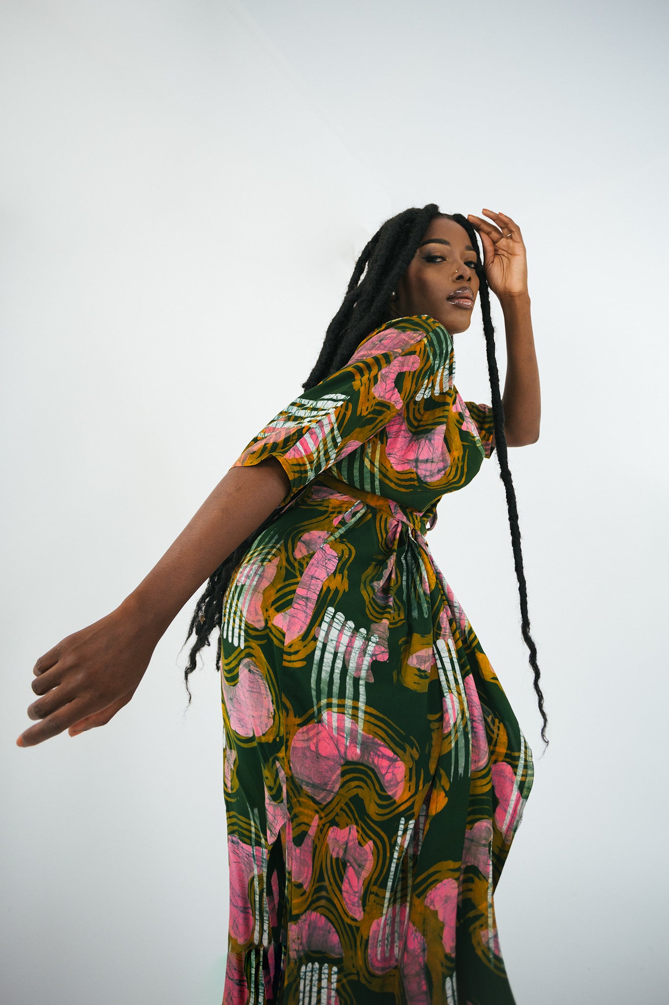 Profile view of a model in a pink and green Letsa Dress, showcasing Osei Duro’s vibrant design.