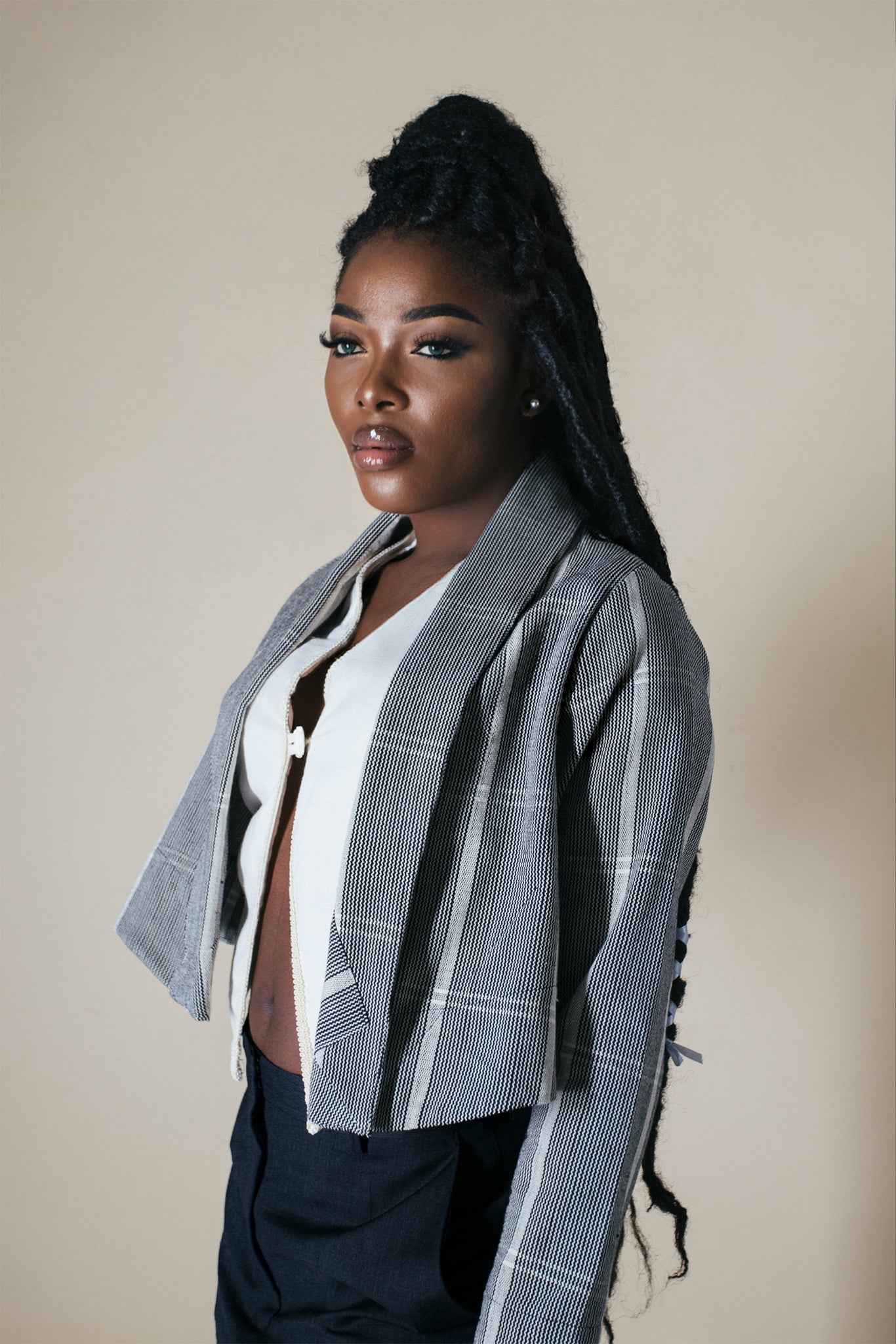 Model in handwoven Abiba Jacket and white shirt stand, exuding a professional yet enigmatic vibe.