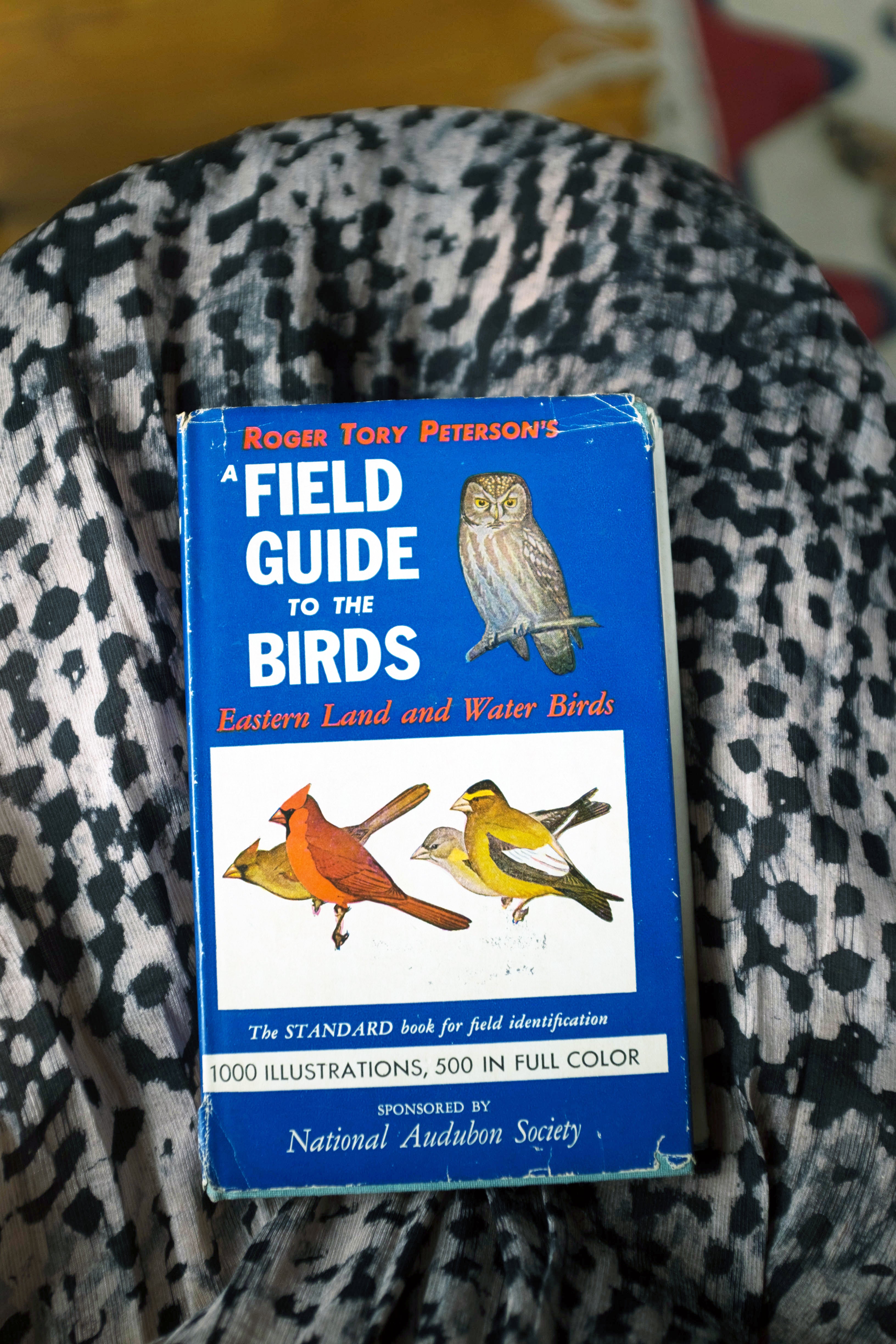 A book titled ‘A Field Guide to the Birds’ by Roger Tory Peterson sitting on Osei-Duro Snakebite fabric.