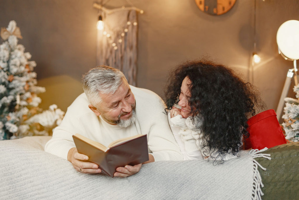 man and woman reading on a bed