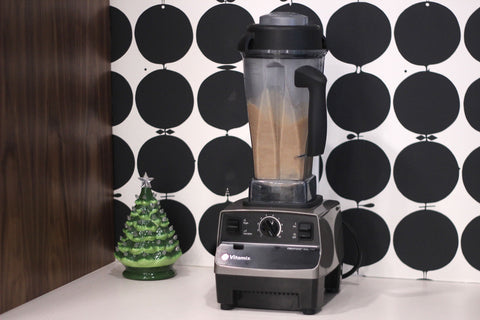 A blender mixes up an eggnog drink on a countertop. 