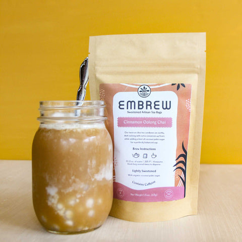 A pouch of Embrew's Cinnamon Oolong Chai and a glass of boba bubble tea. 