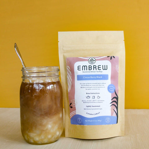 A pouch of Embrew's Cocoa Berry Black tea and a glass of boba bubble tea.