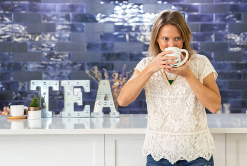 Ashley Haywood, owner and founder of Embrew, drinking tea from a mug.