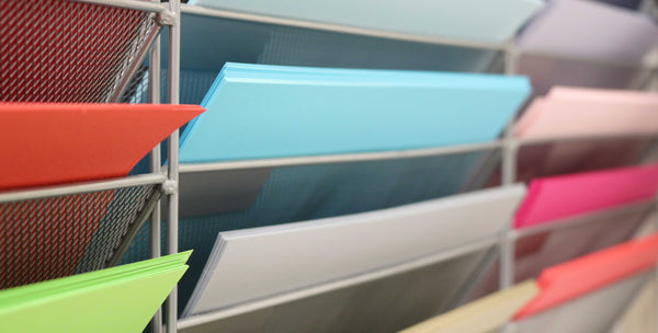 image shows coloured papers stacked in magazine racks