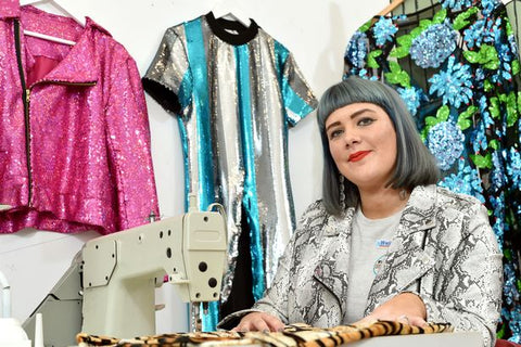 fashion designer Samantha Paton sits behind sewing machine in the Isolated Heroes design studio in Scotland