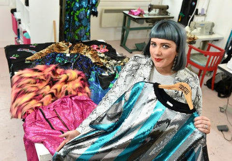 Designer Samantha Paton stands in her fashion design studio with her latest collection