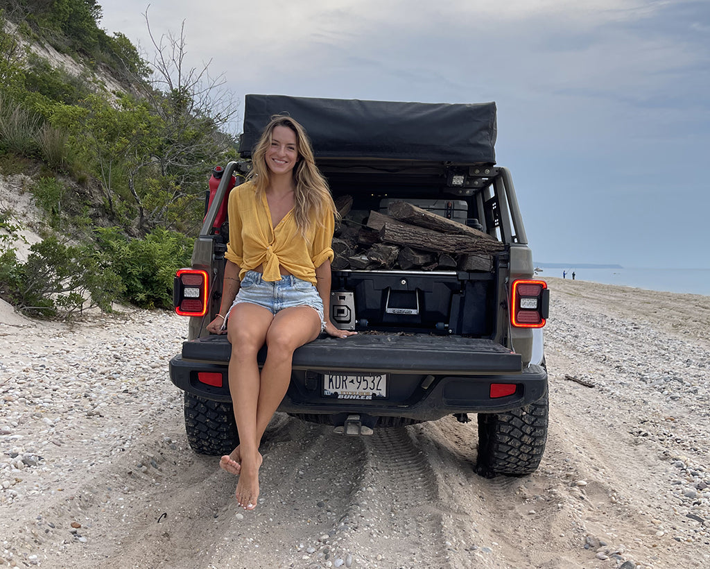 Aneta sits on the tailgate of her Jeep Gladiator