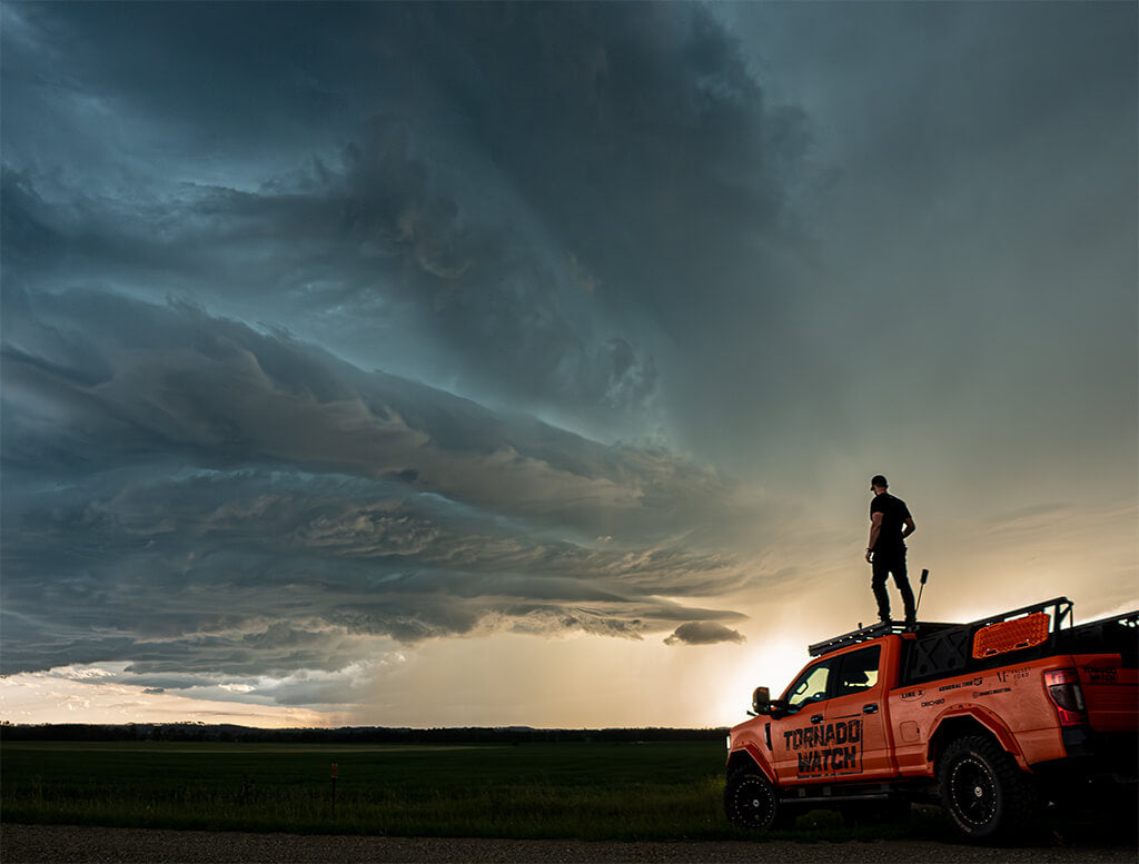 Ricky Forbes stands on top of Brutus, his F250 storm chasing truck