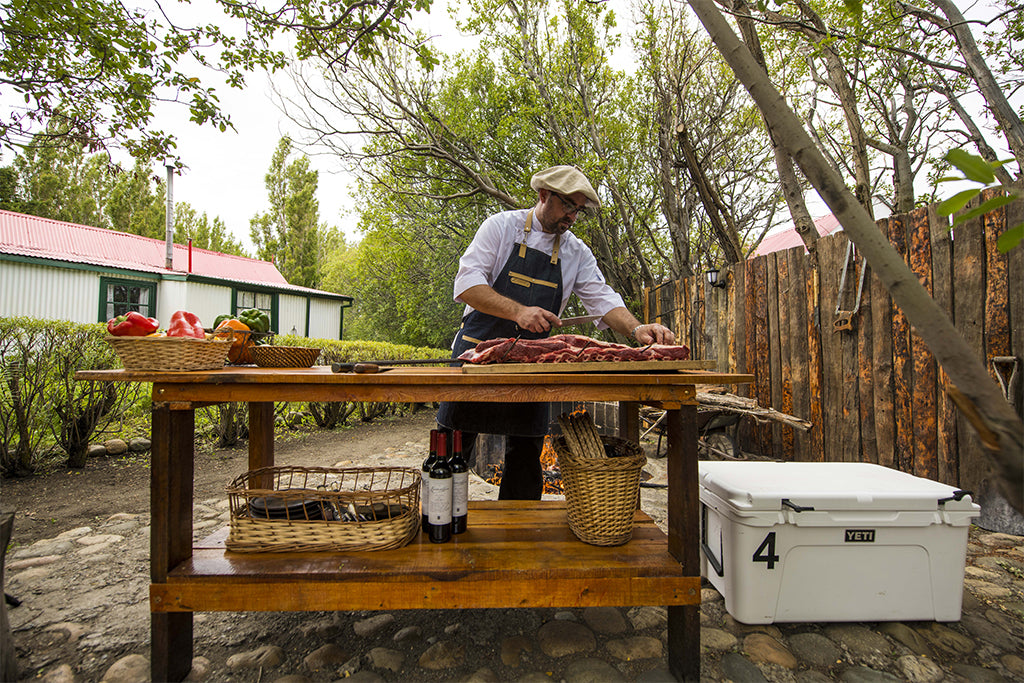 A man prepares a side of beef for a traditional Argentine barbecue