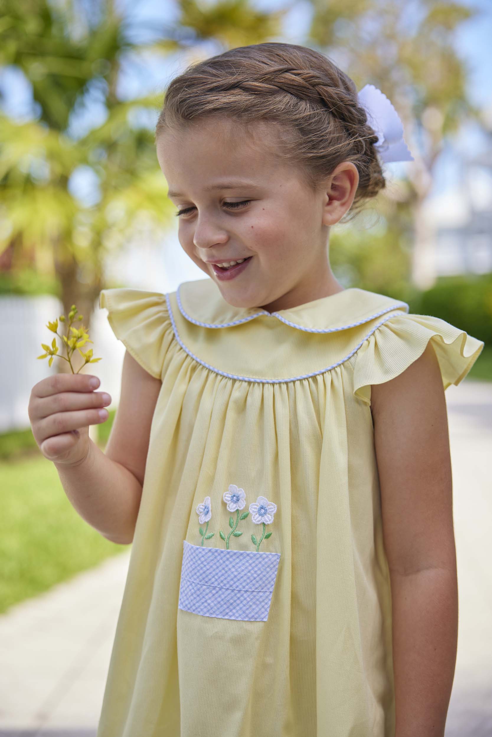 classic childrens clothing yellow dress with peter pan collar and front pocket with daisy embroidery