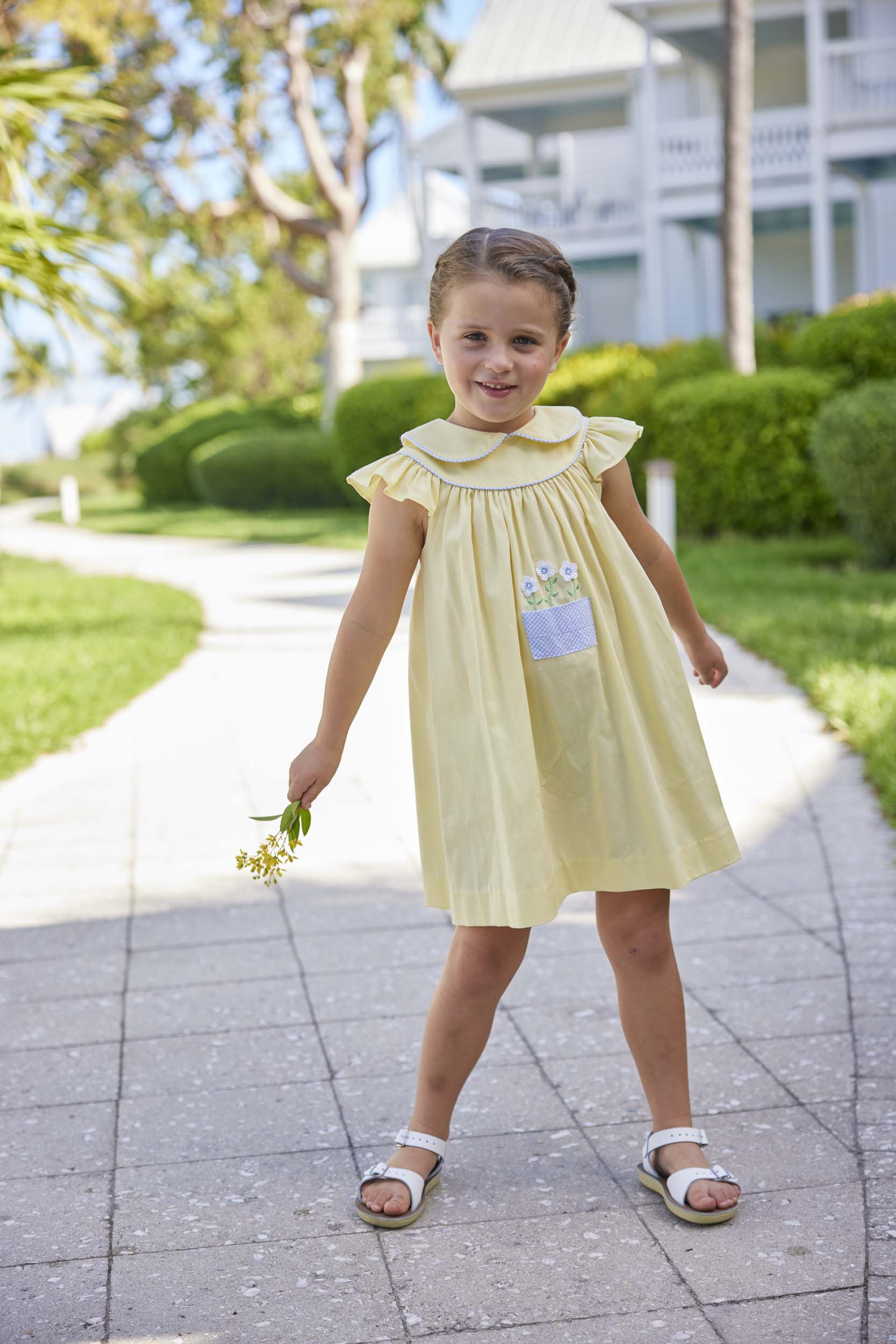 classic childrens clothing yellow dress with peter pan collar and front pocket with daisy embroidery