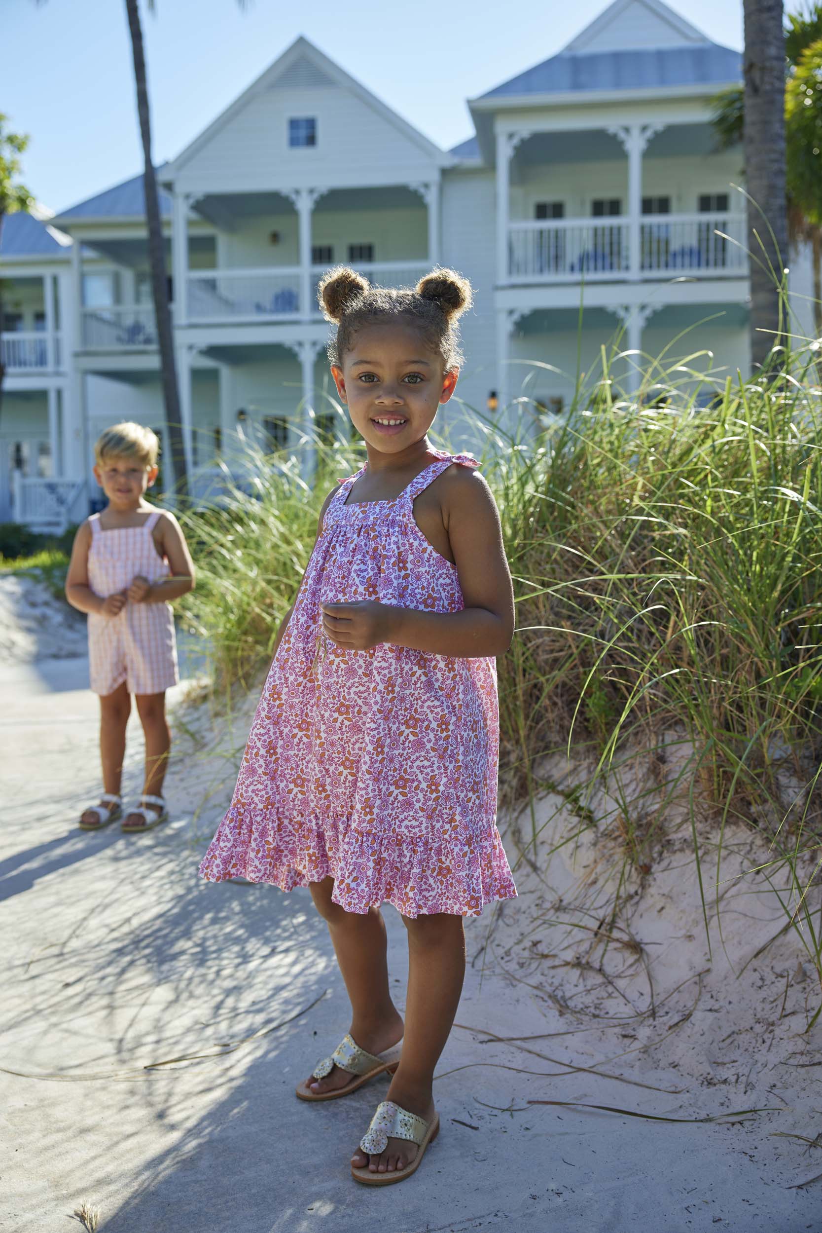 classic childrens clothing girls strapless dress in pink and orange floral print with bows on the sleeve straps