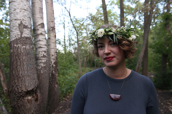 Portrait of Amber Aasman owner of Wild Blue Yonder in the forest with floral crown