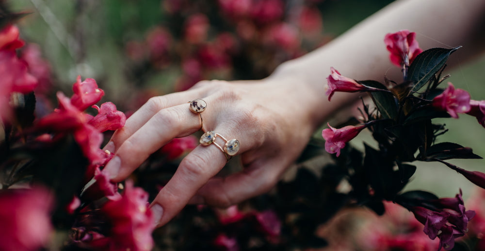 Hand displaying handmade rings made by Wild Blue Yonder Jewelry