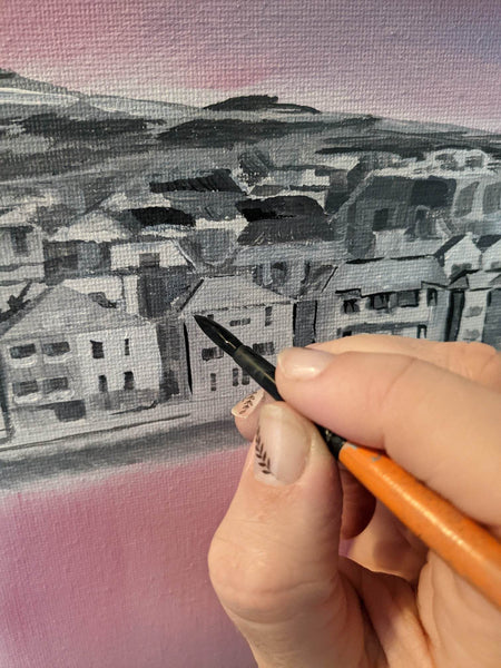painting final outlines of buildings with small paint brush