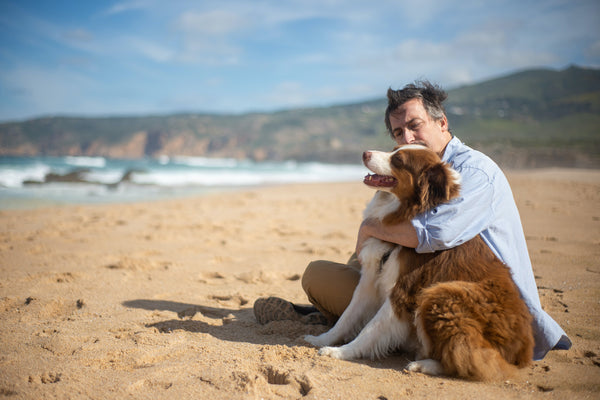 man on beach with his dog