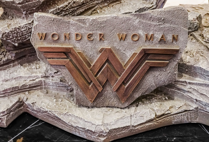 wonder woman with its logo written on a stone