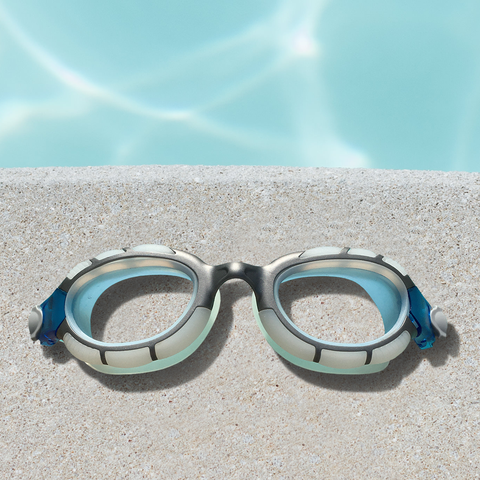 Pair of swimming goggles by a pool