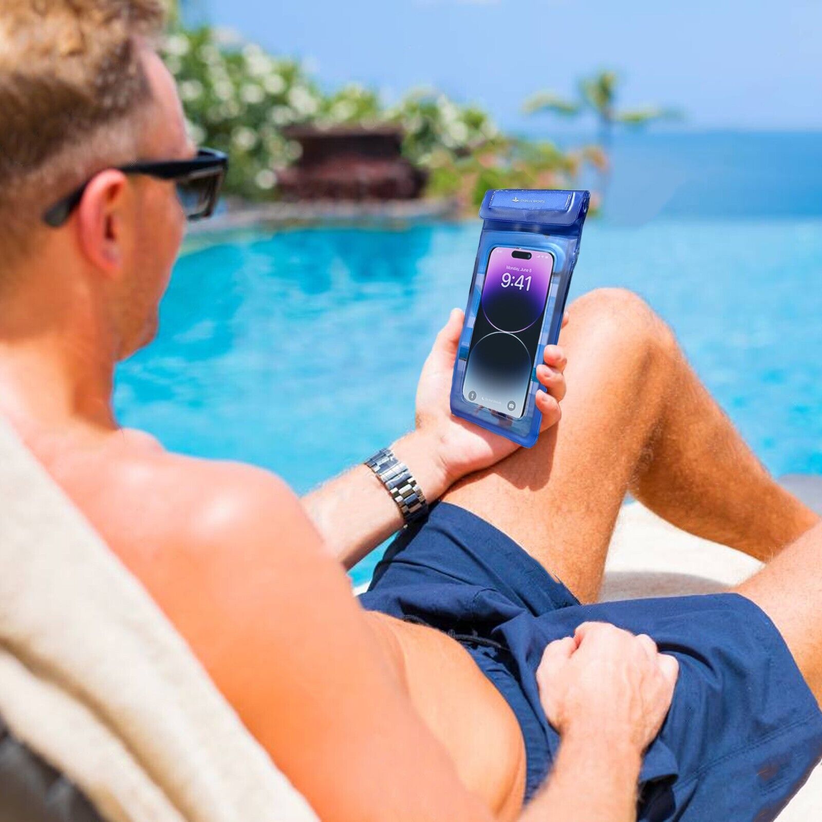 Male using his phone inside of a waterproof pouch relaxing at poolside