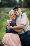 A smiling older couple, Karen Seyler and her husband, standing close to each other. Karen wears a Dexcom G6 to help manager her blood sugar. They both appear happy and relaxed.