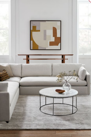 A minimalist living room featuring the Classic Console Table placed under the wall art and behind the sofa in this minimalist living room.